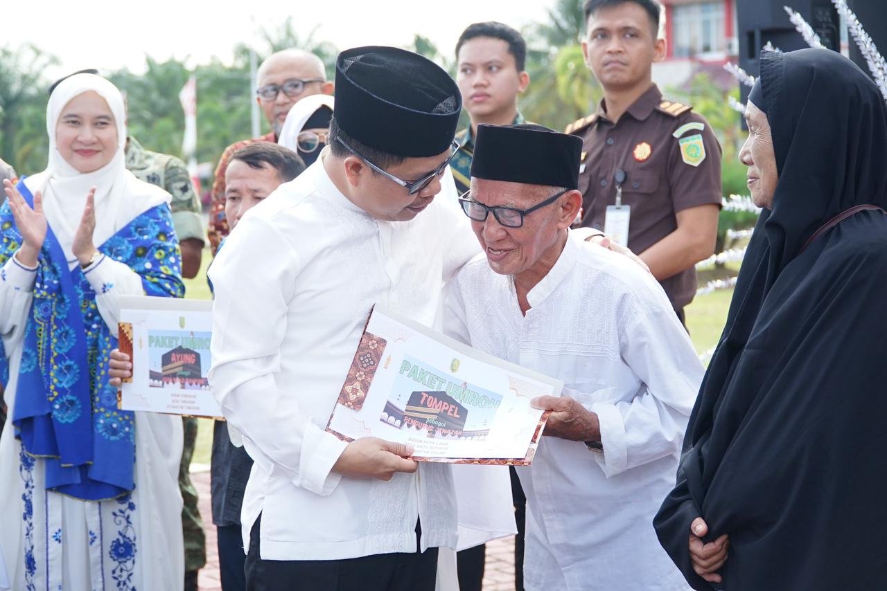 Bupati Sambas, Satono menyerahkan hadiah umrah gratis kepada guru ngaji, iman masjid dan pengurus jenazah di momen peringatan Tahun Baru Islam.