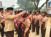 Ketua DPRD Kabupaten Mempawah, Safruddin Asra mengalungkan lencana Pramuka Garuda kepada anggota Pramuka di Sungai Pinyuh.