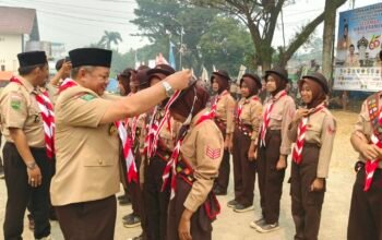Ketua DPRD Kabupaten Mempawah, Safruddin Asra mengalungkan lencana Pramuka Garuda kepada anggota Pramuka di Sungai Pinyuh.