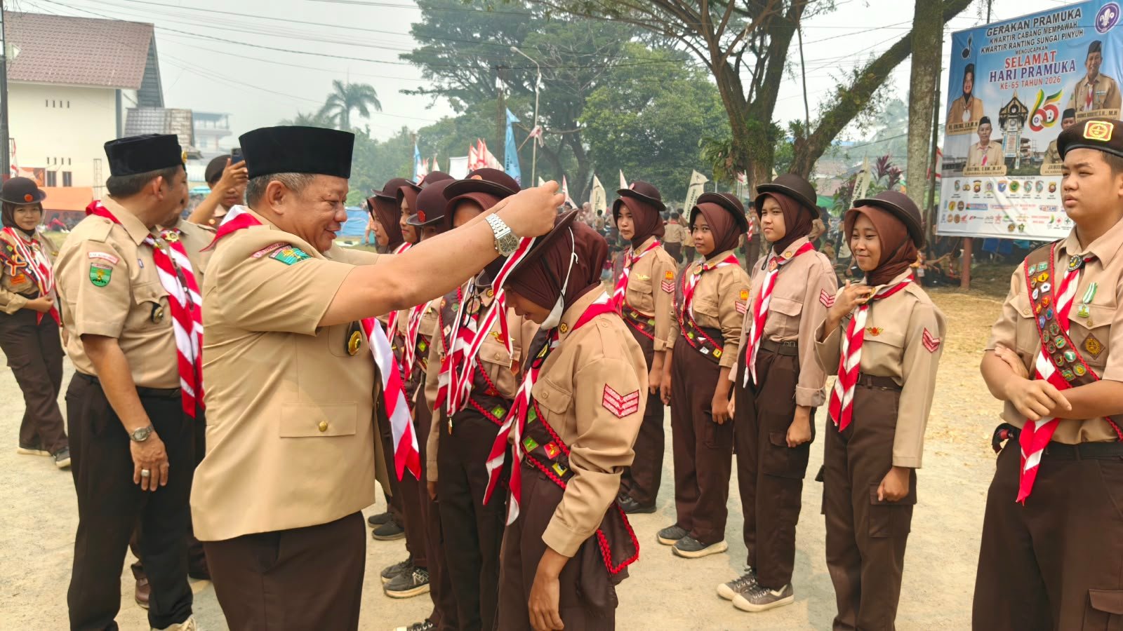 Ketua DPRD Kabupaten Mempawah, Safruddin Asra mengalungkan lencana Pramuka Garuda kepada anggota Pramuka di Sungai Pinyuh.