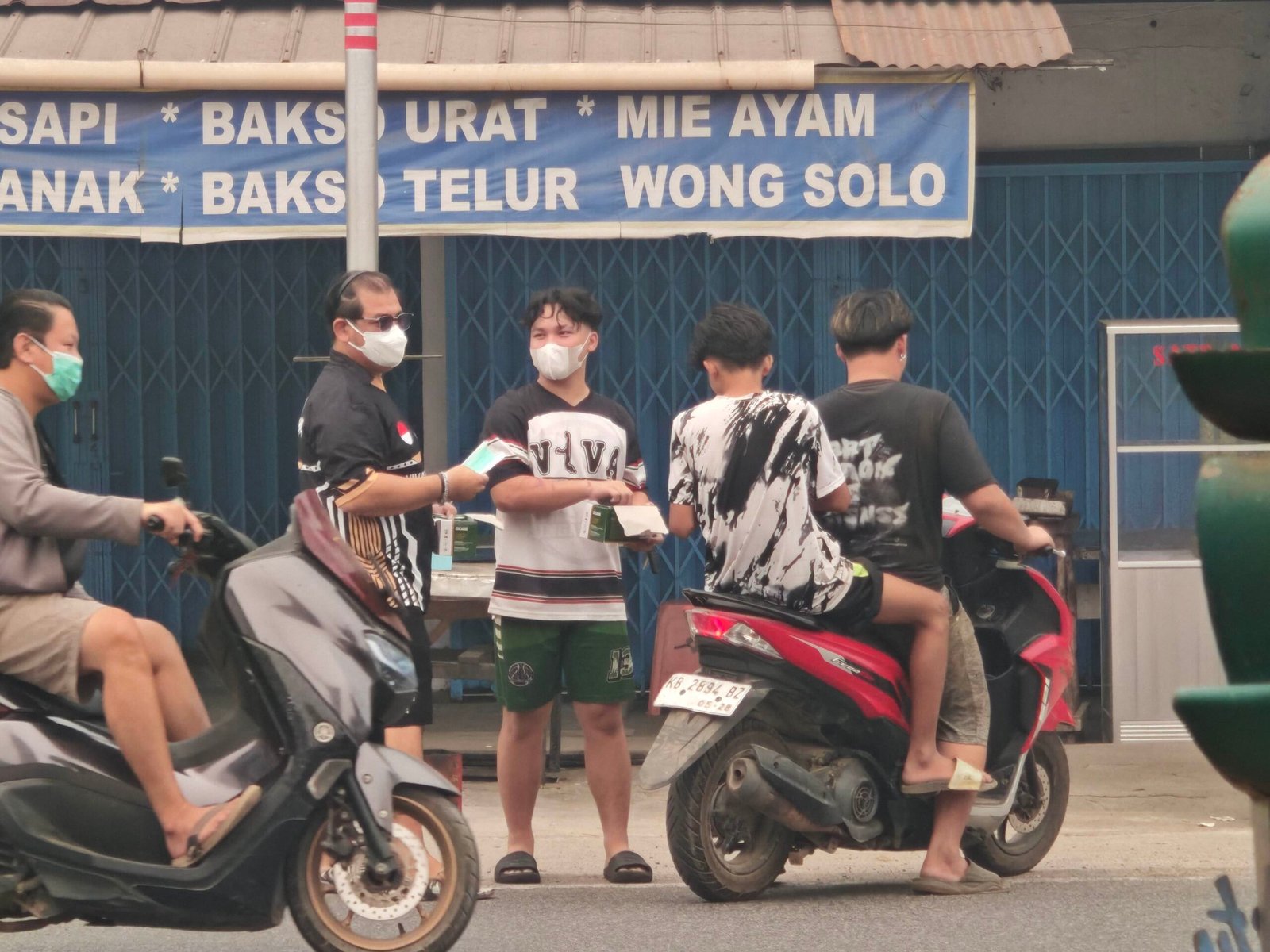 Sejumlah relawan di Sungai Pinyuh bagikan masker untuk pengguna jalan.
